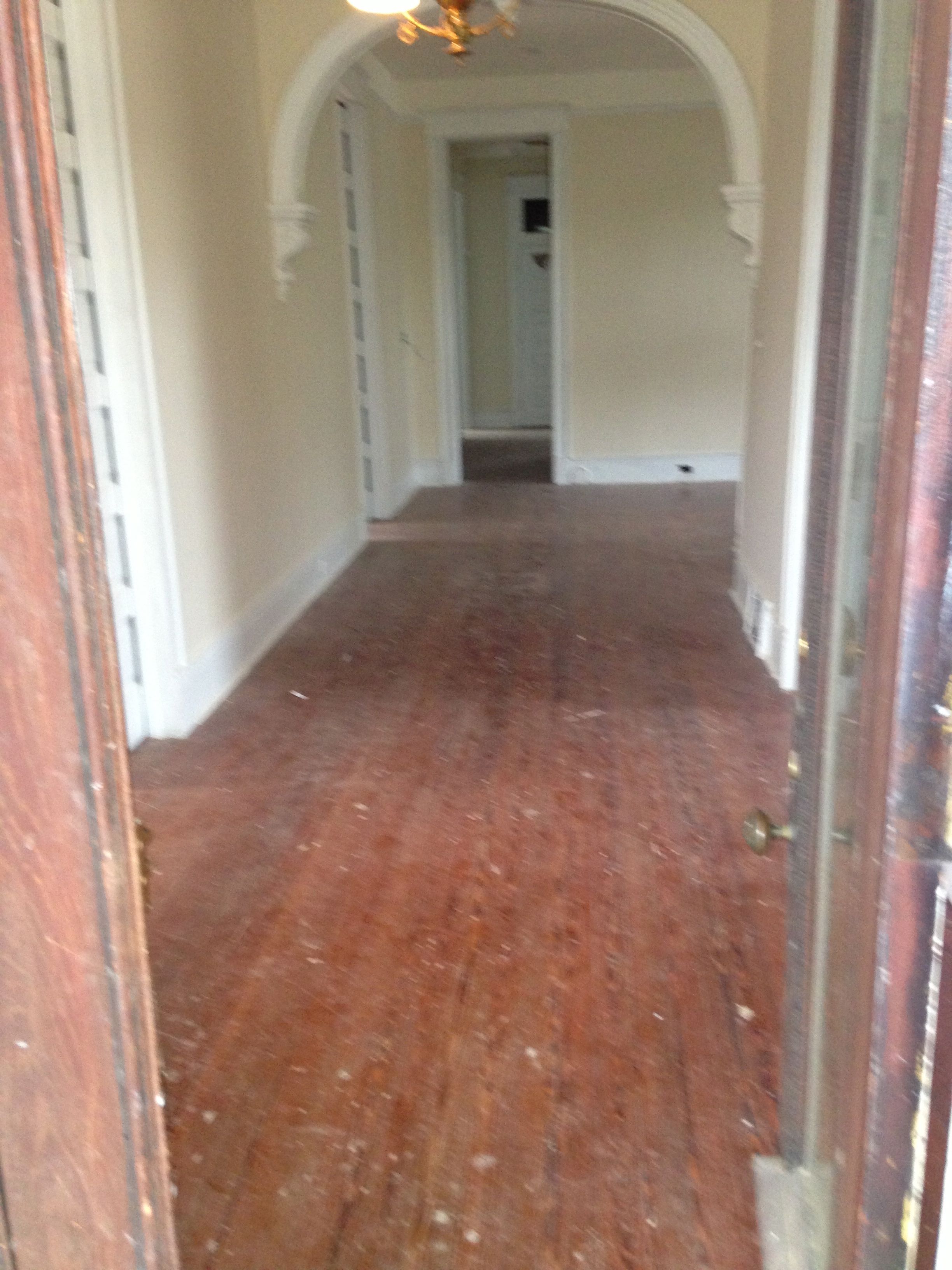 Pictured dusty and scuffed hardwood floors prior to refinishing