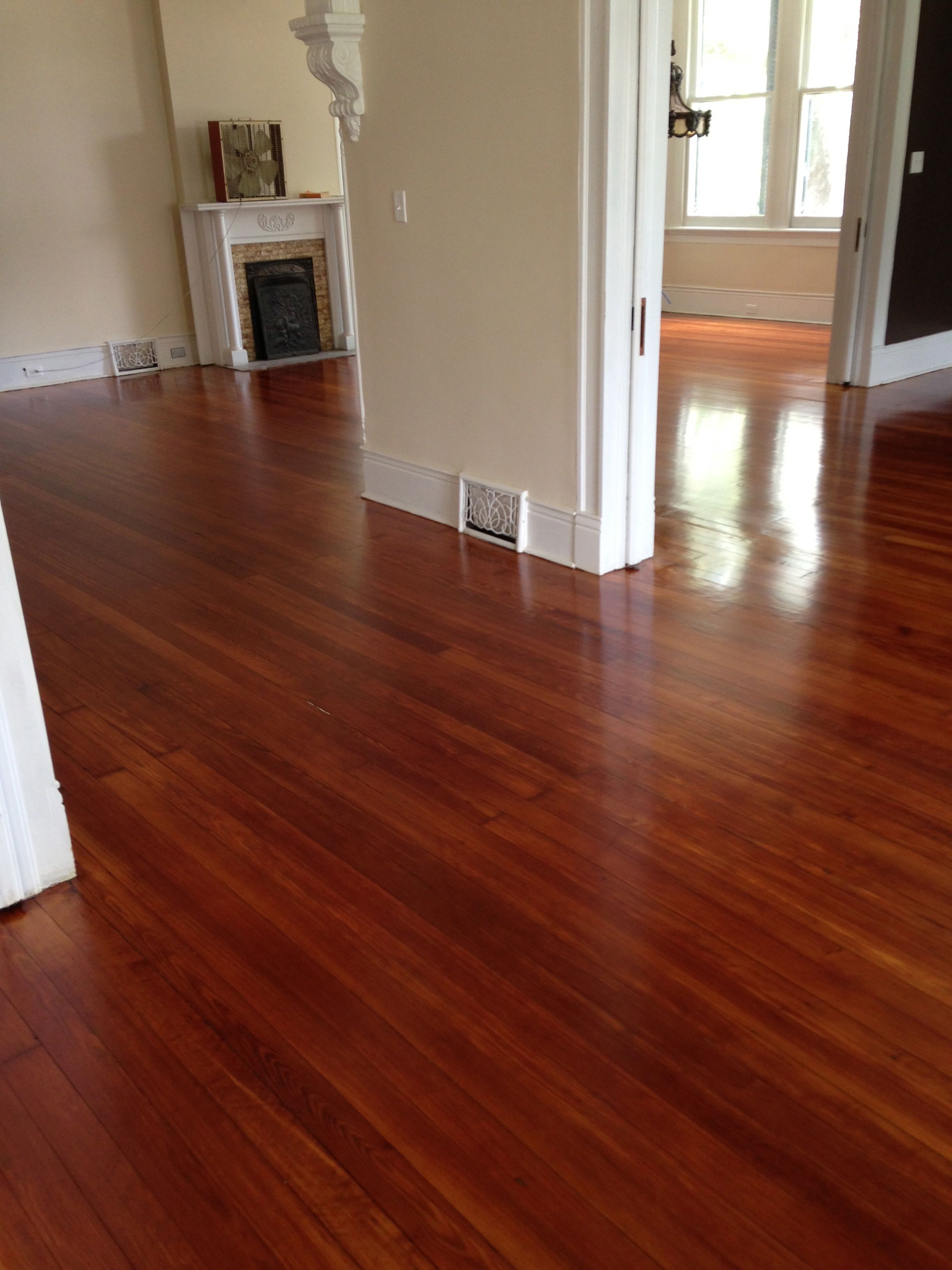 Shiny polyurethaned hardwood floors in living room with a fireplace
