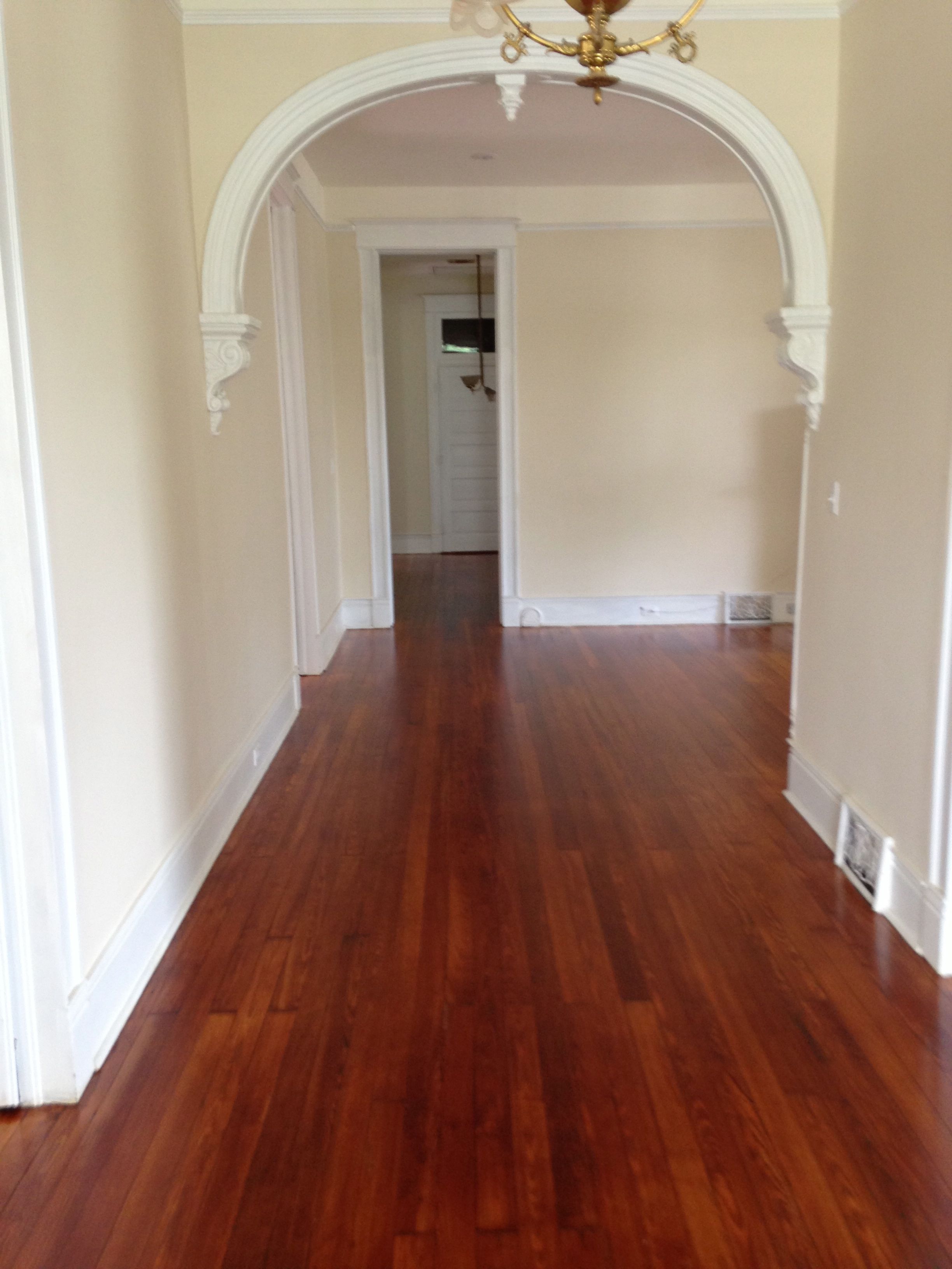Polyurethaned hardwood floors in an arched hallway