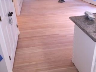 Photo of sanded new flooring after tile removal.