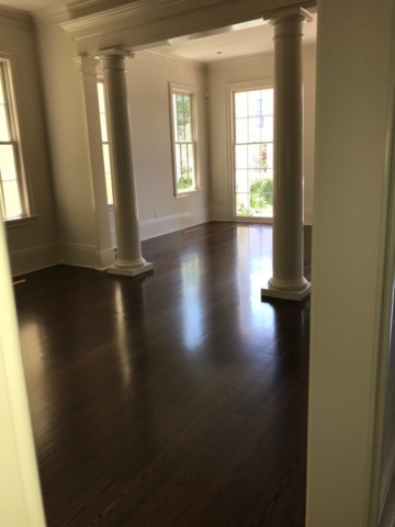 Pictured is a living room with dark stained red pine hardwood flooring.