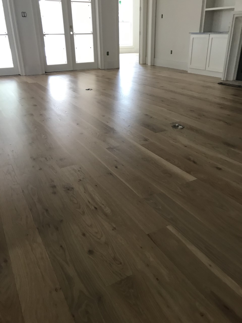This is a photo of a living room with white oak flooring with a satin finish. It has a weather washed appearance.
