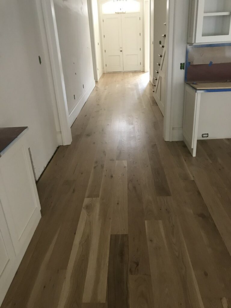 This is a photo of a kitchen with white oak flooring with a satin finish. It has a weather washed appearance.