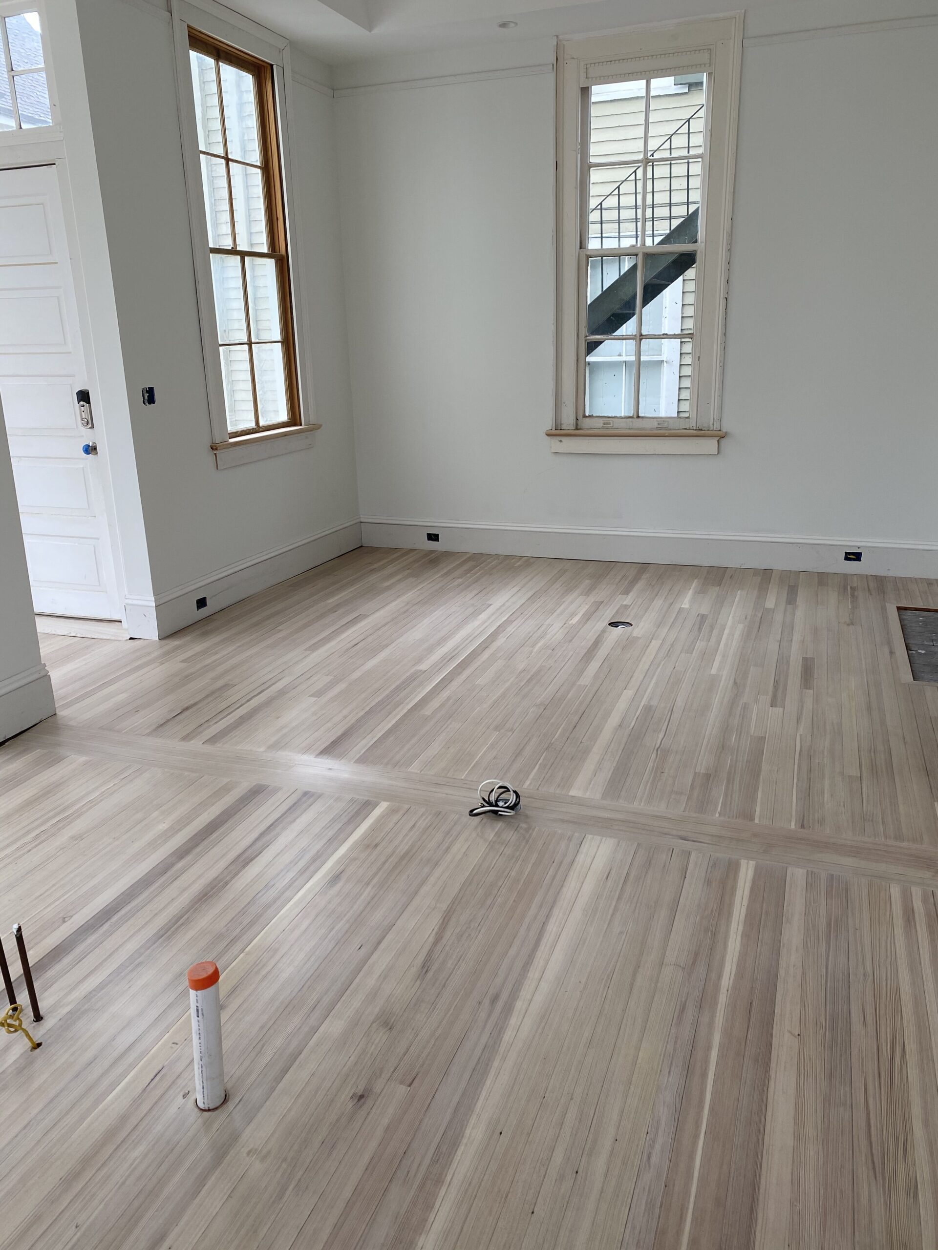 Beautiful white wash finish red heart of pine hardwood flooring in a den area with white walls