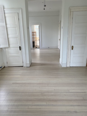 Two rooms of bleached with a white wash hardwood flooring