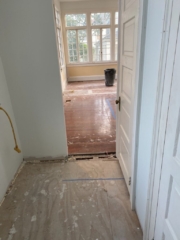 Before photo of stripped hallway and room with red heart of pine prior to bleaching with a white wash finish